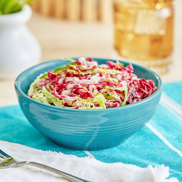 A close-up of an Acopa Capri Caribbean Turquoise Nappie Bowl filled with coleslaw.