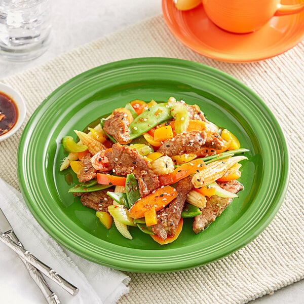 A close-up of Acopa Capri Palm Green Stoneware Plate with food on it.