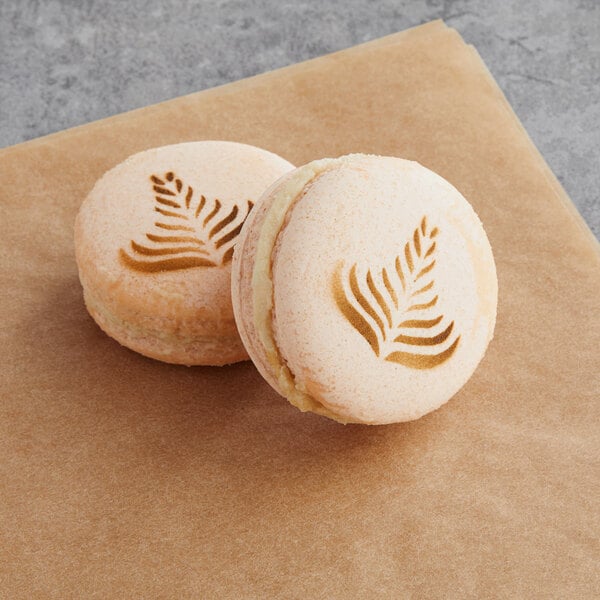 Two Macarons with a leaf design on top.