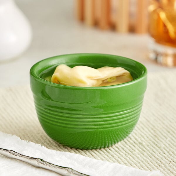 An Acopa Capri palm green stoneware bouillon cup filled with food on a white surface.