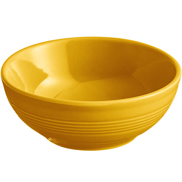 An Acopa Capri mango orange stoneware bowl filled with food on a white background.