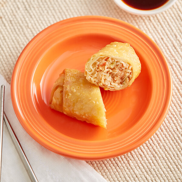 An Acopa Valencia orange stoneware plate with food on it.