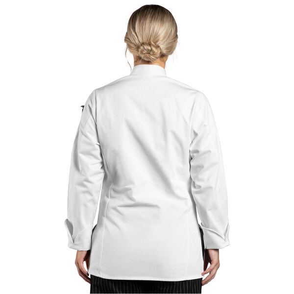 A woman wearing a white Uncommon Chef long sleeve chef coat with white collar and black cuffs.