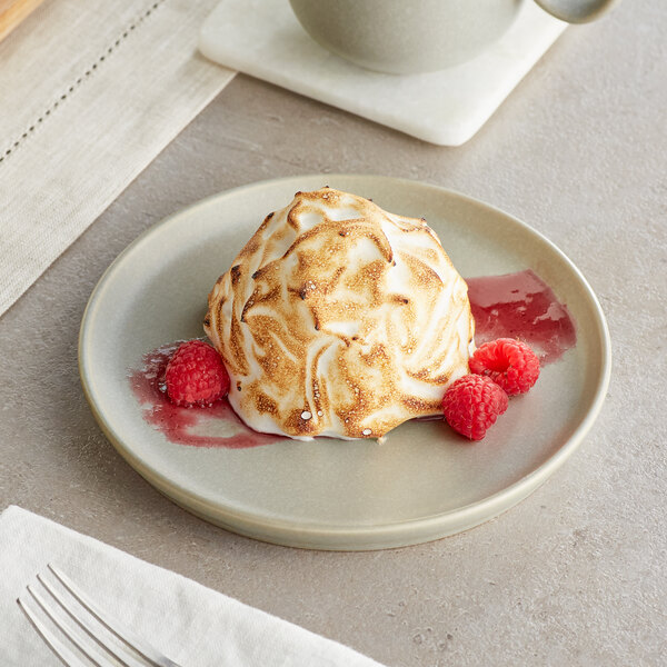 A dessert with raspberries on an Acopa Pangea ash matte coupe plate.