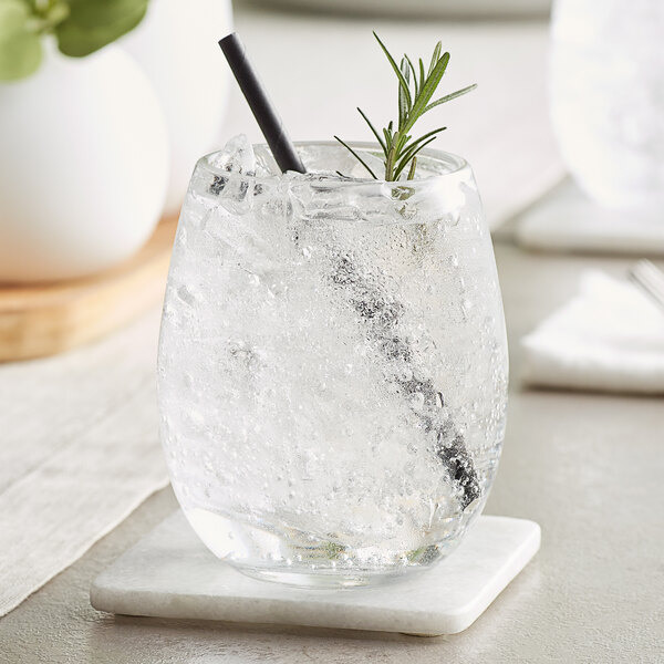 A stemless Acopa Pangea wine glass with ice and a straw in it.