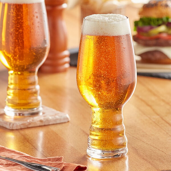 An Acopa Select IPA beer glass filled with beer on a table in a brewery tasting room.