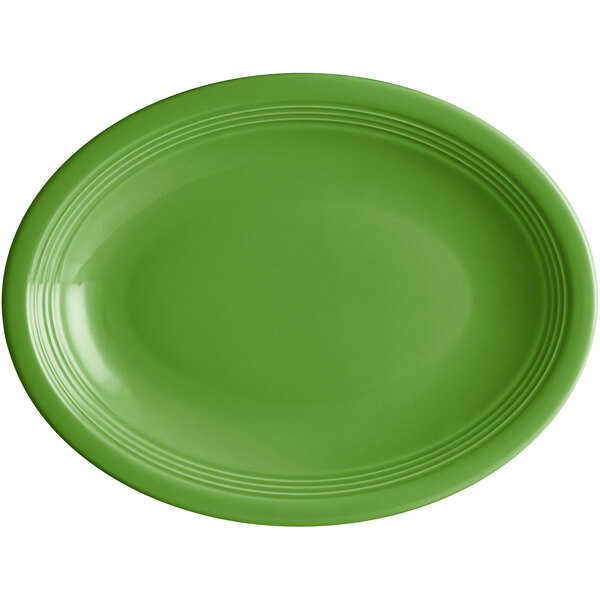 An oval palm green stoneware coupe platter with a rim, white background.