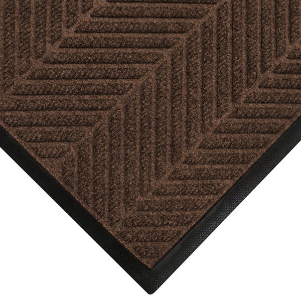 A brown M+A Matting WaterHog mat with black trim.