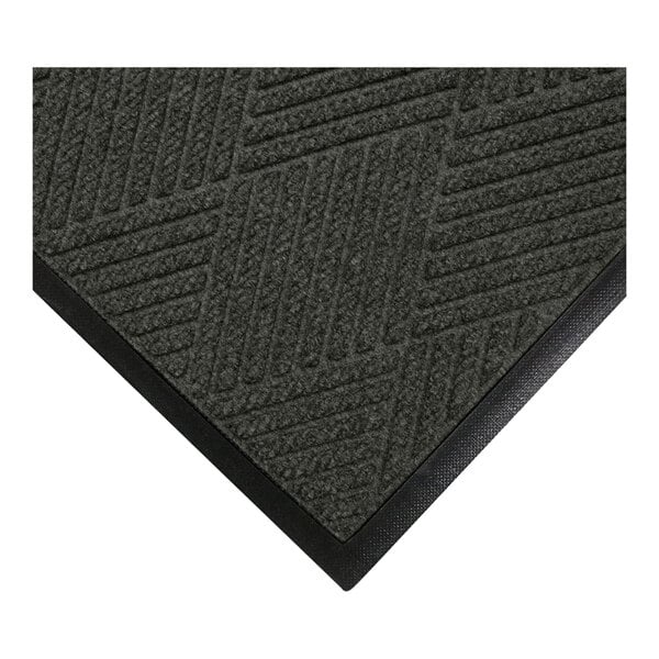 A close-up view of a dark textured mat with a geometric pattern and a black rubber border.