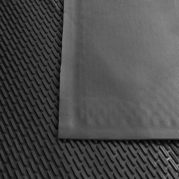 A close-up of a black Lavex rubber ridge-scraper safety mat.