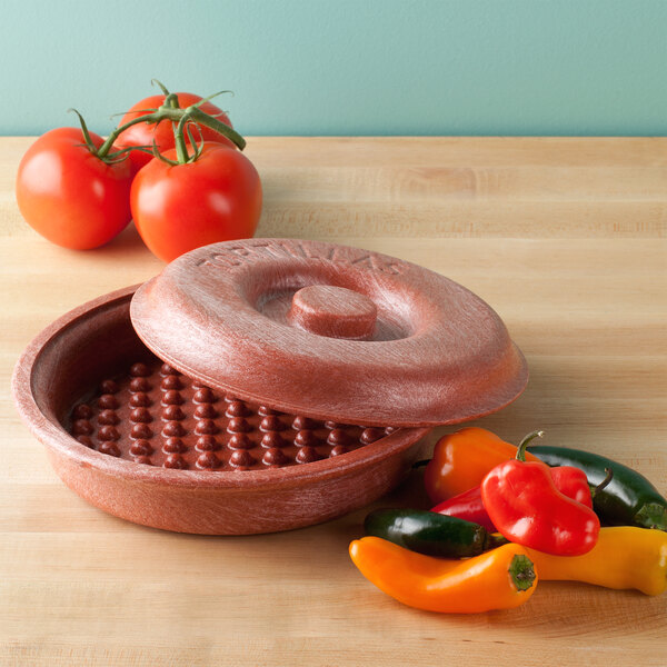 A red Polyethylene "Tortilla Pleezer" with a lid on a table with peppers.