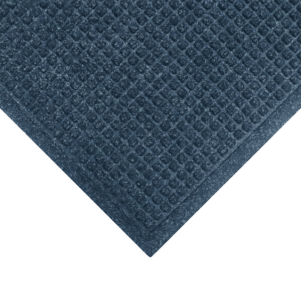 A medium blue WaterHog entrance mat with a diamond pattern and a fabric border.