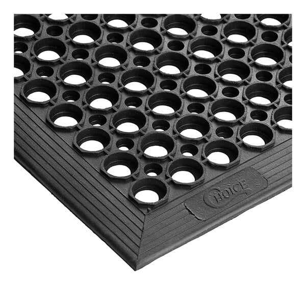 A close-up of a black rubber Choice anti-fatigue floor mat with holes in the middle.