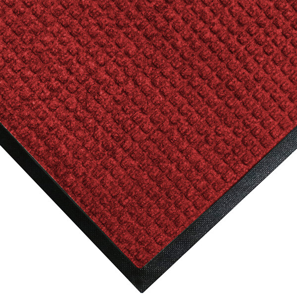 A red WaterHog doormat with black trim.