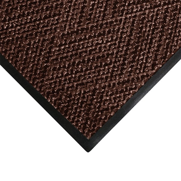 A brown M+A Matting doormat with black trim.