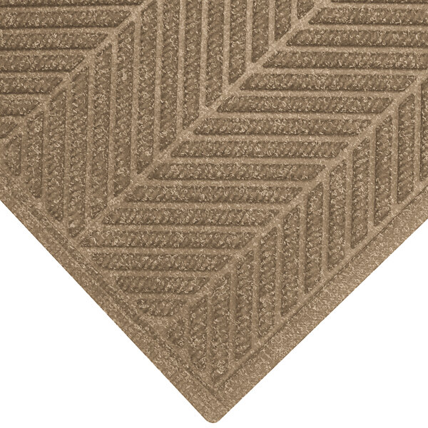 A khaki WaterHog mat with a chevron pattern and fashion border.