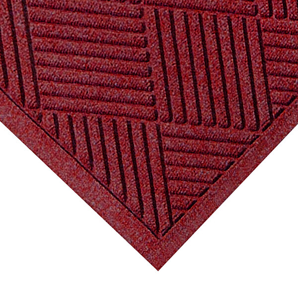 A red M+A Matting WaterHog mat with a square pattern and fashion fabric border.
