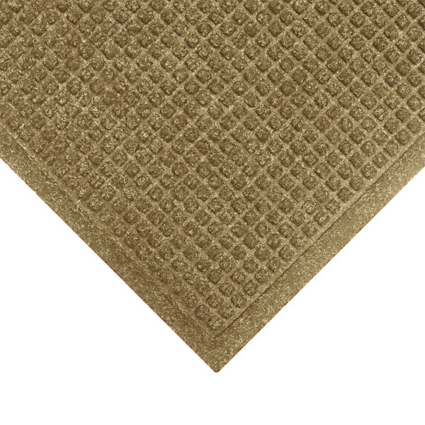 A brown M+A Matting WaterHog mat with a diamond pattern and fabric border.