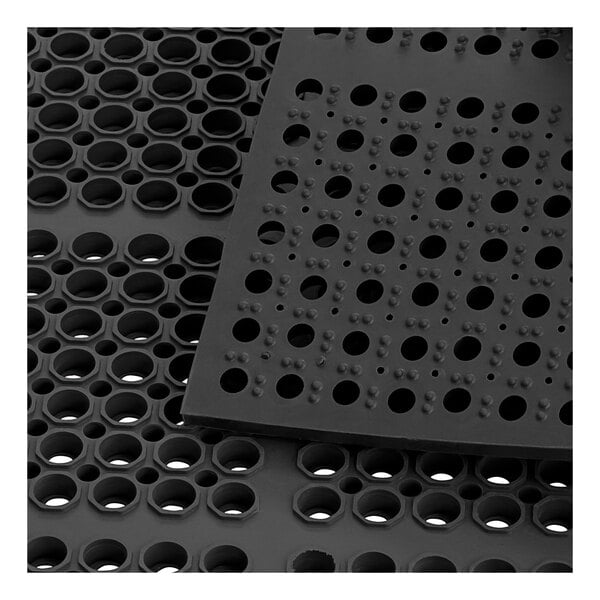 A black rubber anti-fatigue floor mat with holes in it.