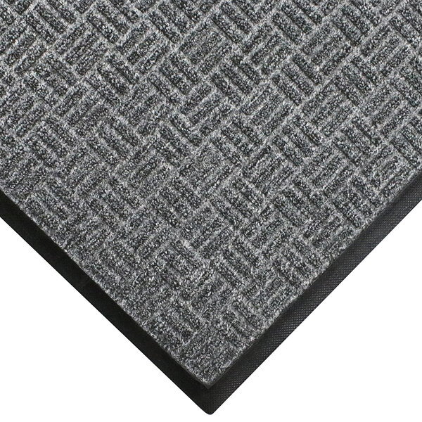 A close-up of a grey WaterHog Masterpiece doormat with a black border.