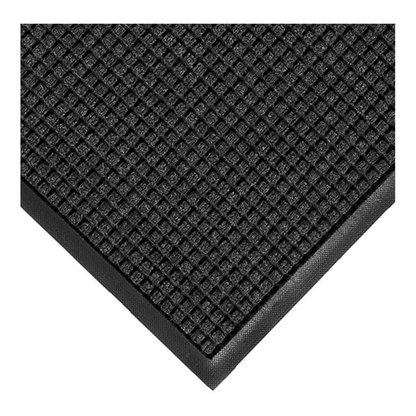 A close-up view of a dark, textured mat with a grid pattern and a smooth rubber border.