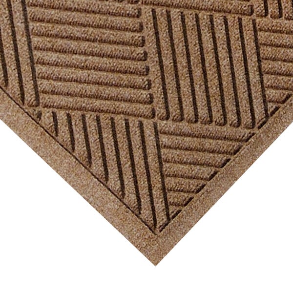 A close-up of a brown M+A Matting WaterHog mat with a square pattern.