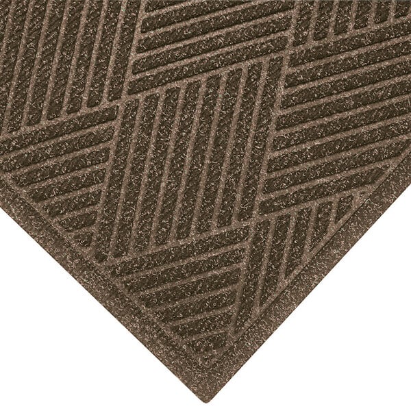 A khaki WaterHog mat with a patterned fabric border.