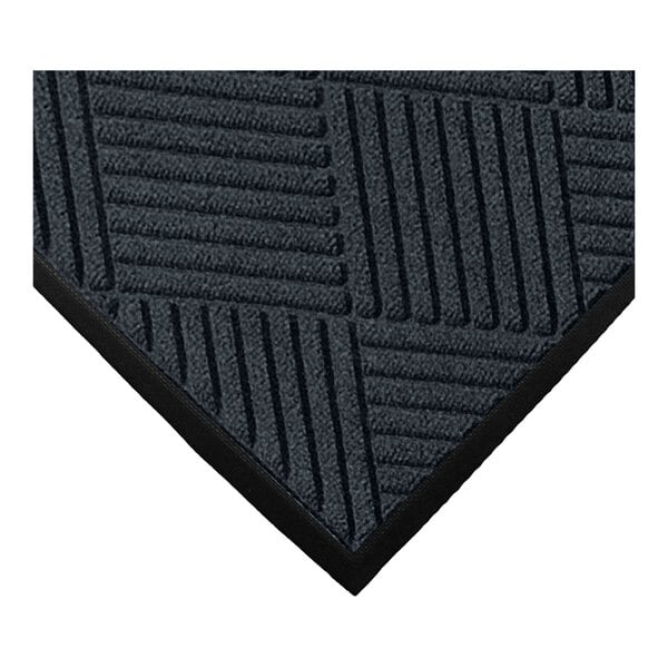 A close-up of a dark-colored mat with a geometric, diamond-patterned texture and a black border.