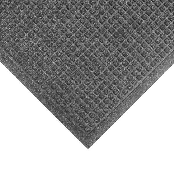 A close-up of a grey WaterHog mat with a square pattern in the fabric border.