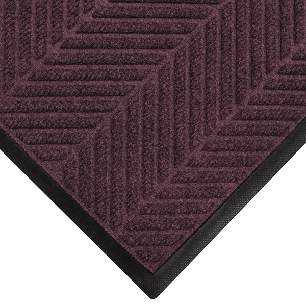 A maroon WaterHog mat with black trim and a classic border.