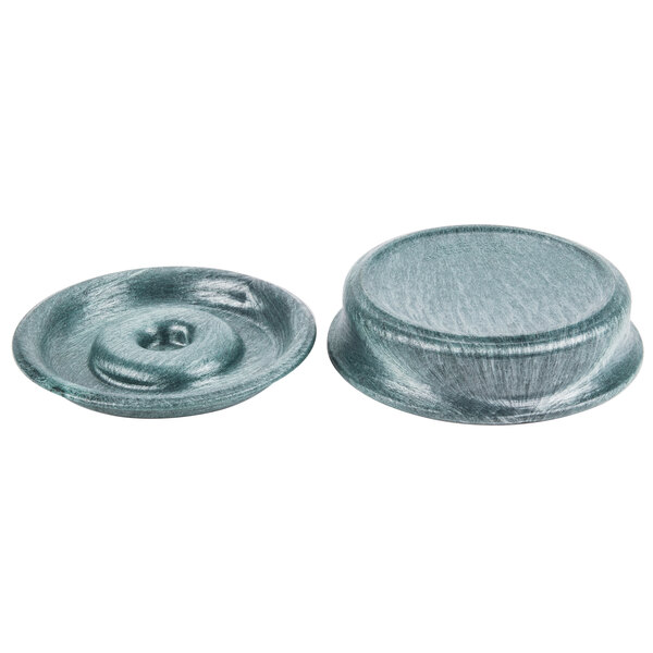 A close-up of a round bowl with two green buttons with a hole in it.