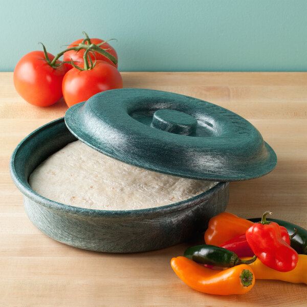 A white polyethylene bowl with a lid filled with tortillas on a kitchen counter.