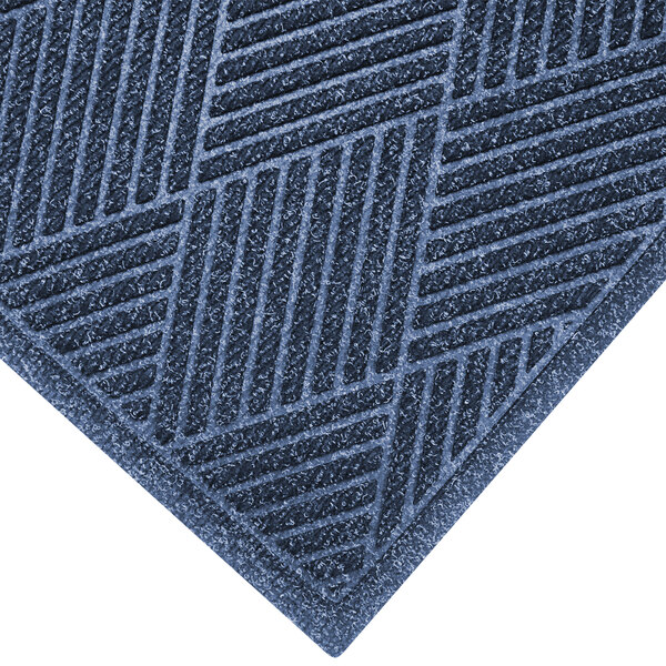 An indigo WaterHog mat with a diagonal fabric border.