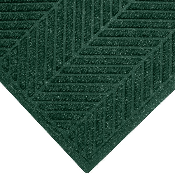 A close-up of a green WaterHog mat with a chevron pattern and a fashion border.