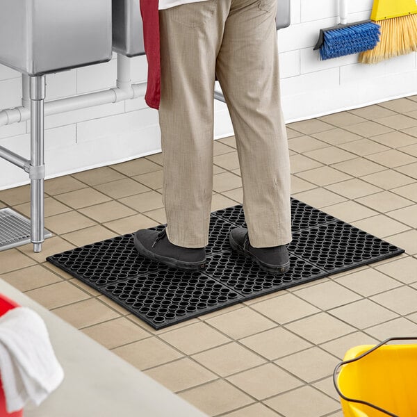 A man standing on a black Lavex anti-fatigue floor mat.