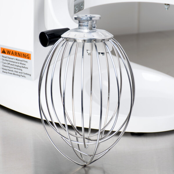 A Globe stainless steel wire whip attachment on a white surface.