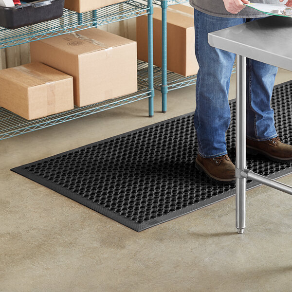 A man standing on a black Lavex anti-fatigue floor mat.