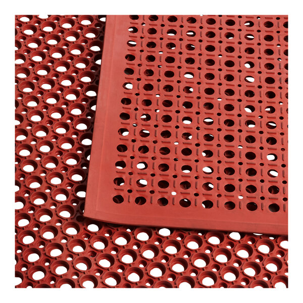 A red rubber Lavex anti-fatigue floor mat with holes.
