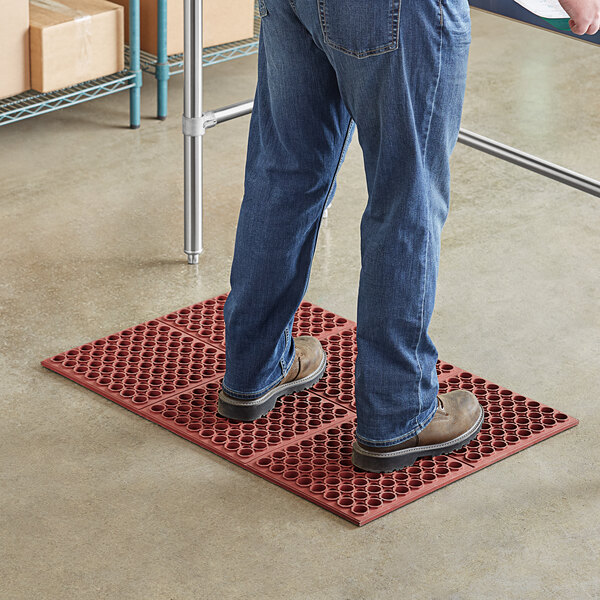 A man standing on a red Lavex rubber anti-fatigue floor mat.