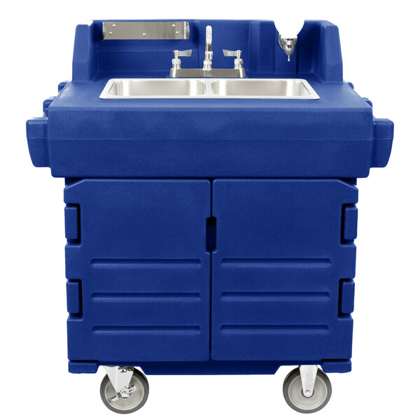 A navy blue plastic Cambro CamKiosk portable sink with a stainless steel sink on a counter with wheels.