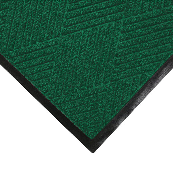 A green WaterHog doormat with black rubber trim.