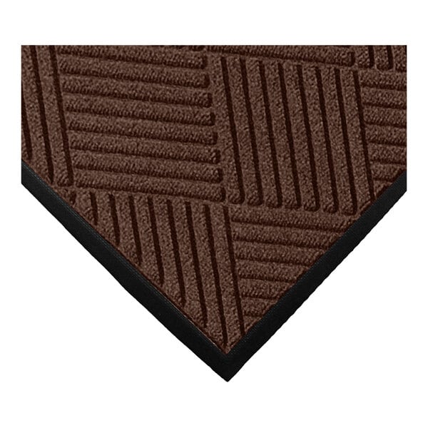 A close-up of a brown mat with a geometric diamond pattern and a black rubber border.