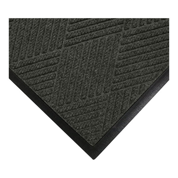 A close-up view of a dark textured mat with a geometric pattern and a black rubber border.
