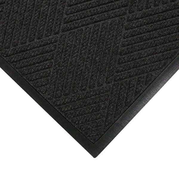 A close up of a black M+A Matting WaterHog Eco Premier mat with a patterned rubber border.