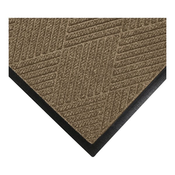 A close-up view of a brown textured mat with a geometric pattern and a black rubber border.