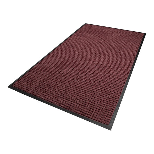 A rectangular mat with a textured, burgundy surface and a black border.