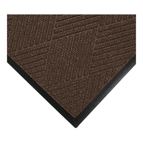 A close-up view of a brown textured mat with a geometric pattern and a black rubber border.