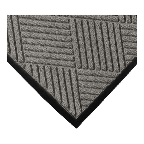 A close-up of a gray mat with a geometric diamond pattern and a black border.
