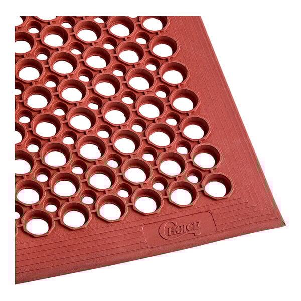 A close-up of a red Choice rubber anti-fatigue floor mat with holes in it.
