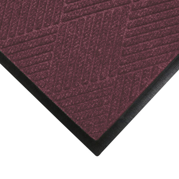 A maroon WaterHog mat with black rubber border.